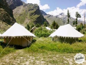 two tents in a field with mountains in the background at Jispa Journey Camp Lahoul & Spiti in Manāli