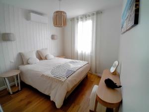 a bedroom with a bed and a table and a window at Thoiras La Belle de Saint-Martin in Saint-Martin-de-Ré