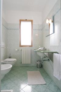 La salle de bains blanche est pourvue d'un lavabo et de toilettes. dans l'établissement Motel Monterosa, à Vogogna