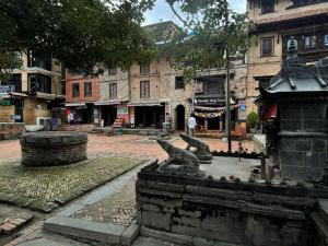 una strada di città con la statua di un uccello su una fontana di Patan Square - 2 km from Patan Durbar Square a Patan Altre 25 foto