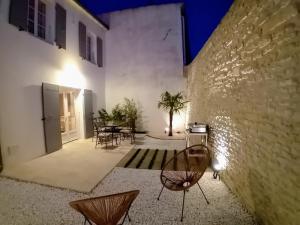 a courtyard with a table and chairs in a building at Thoiras La Belle de Saint-Martin in Saint-Martin-de-Ré