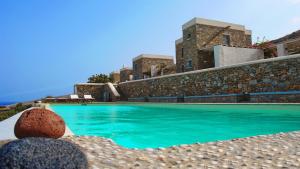 a swimming pool in front of a building at Folegandros Villas Aspropounta Double Room Beachfront in Chora Folegandros