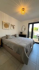 ein Schlafzimmer mit einem großen Bett mit einem großen Fenster in der Unterkunft Appartement T2 - Rez-de-Jardin, proche plage et commerces in Calvi