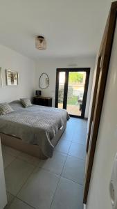ein Schlafzimmer mit einem Bett und einem großen Fenster in der Unterkunft Appartement T2 - Rez-de-Jardin, proche plage et commerces in Calvi + 19 Fotos