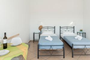 Postel nebo postele na pokoji v ubytování Aegean Blue Santorini Perivolos 1