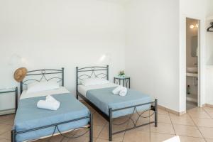 Postel nebo postele na pokoji v ubytování Aegean Blue Santorini Perivolos 1