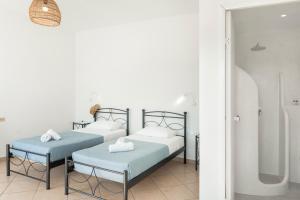 Postel nebo postele na pokoji v ubytování Aegean Blue Santorini Perivolos 1