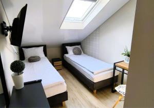 two beds in a small room with a skylight at Restauracja Dajana in Bełchatów