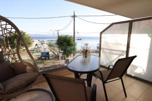a table and chairs in a room with a view of the ocean at Filippos Apartments in Amarynthos