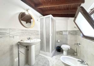 łazienka z umywalką, toaletą i lustrem w obiekcie Solemar Sicilia - Seaside House Capo Zafferano w mieście Santa Flavia +7 zdjęć