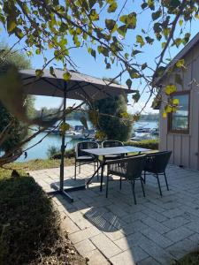 a patio with a table and chairs and an umbrella at Gîte La Capitainerie in Offendorf +3 photos