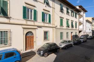 a group of cars parked next to a building with green shutters at Cooker Chianti in Florence