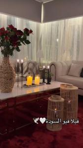 a living room with a table with candles and a couch at فيلا فيو السودة Villa View Al Soudah in Sawdāʼ