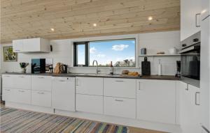 a kitchen with white cabinets and a large window at 3 Bedroom Lovely Home In Hjørring in Hjørring