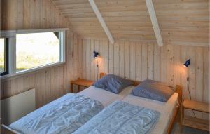 a bedroom with two beds in a wooden cabin at Holiday Home Slettevej Ii in Skagen