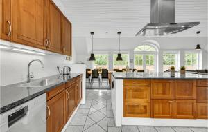 a kitchen with wooden cabinets and a counter top at Awesome Home In Ulfborg With Kitchen in Ulfborg