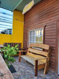 a wooden bench sitting on the side of a building at D's Inn in San Ignacio