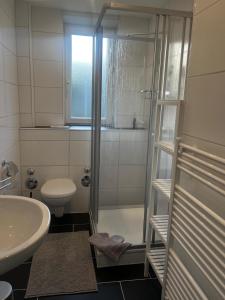 a bathroom with a shower and a toilet and a sink at Appartement No1 in Witten +9 photos