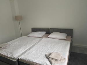 a bed with white sheets and two pillows on it at Appartement No1 in Witten