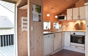 una cucina con elettrodomestici bianchi e pareti in legno di Søndervig Ferieby a Nørby Altre 12 foto