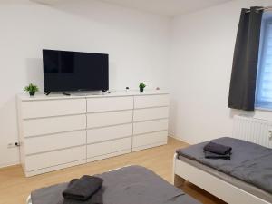 a white dresser with a television on top of it at Beautiful Apartment in Bad Oldesloe in Bad Oldesloe