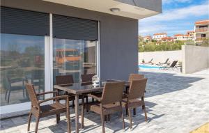 a dining table and chairs on a patio at Cozy Home In Rab With Wifi in Rab