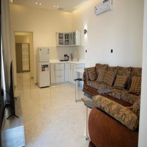 a living room with two couches and a kitchen at شالية الريف in Al Jith