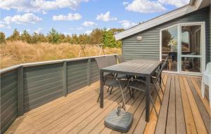 una terraza de madera con una mesa y una silla. en Four-Bedroom Holiday Home In Thisted, en Torsted