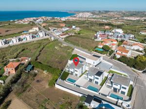 an aerial view of a small town with houses and the ocean at Villa Beach and Friends with ocean view in Lourinhã