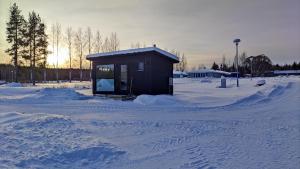 un piccolo edificio in un campo innevato di Kipinä Lomat - Loimu-mökki a Sotkamo