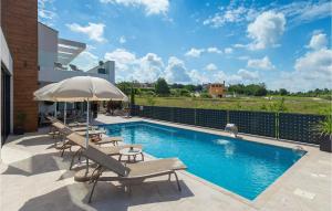 a swimming pool with lounge chairs and an umbrella at Villa Aria in Poreč