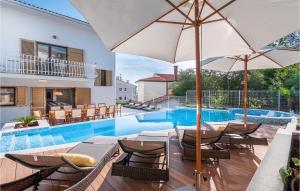 una piscina con sillas y sombrillas junto a una piscina en Villa Blue Dream, en Dramalj