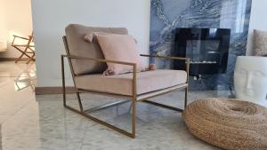 a chair in a room with a rattan stool at Vacaciones de ensueño in Mojácar