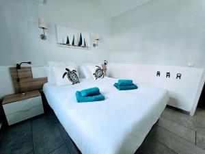 a large white bed with two blue pillows on it at VV Sweet Flamboyan Playaflor 1 "by henrypole home" in Maspalomas +16 photos