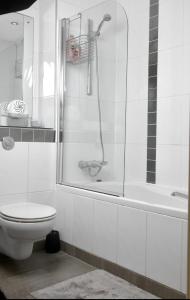 a white bathroom with a shower and a toilet at LUX 2bed City Centre and AO Arena Free Parking Modern Apt in Manchester