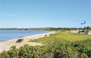 un banc assis sur une plage au bord de l'eau dans l'établissement Three-Bedroom Holiday Home In Ebeltoft, à Ebeltoft