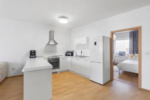 a kitchen with white appliances and a bed in a room at Apartment Puma v centre Piešťan in Piešťany