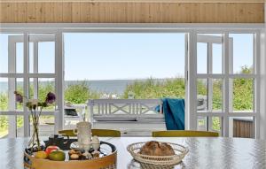 a dining room with a table with a basket of fruit at Three-Bedroom Holiday Home In Knebel in Knebel