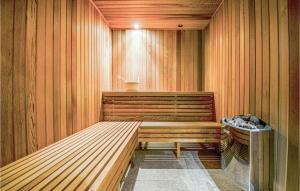 a sauna with a wooden bench in a room at Strandhuset in Knebel
