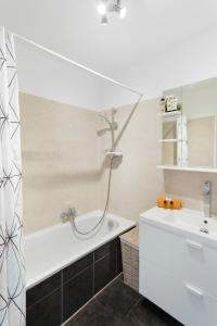 a bathroom with a bath tub and a sink at Le Radieux - Spacious - Bright - Car park - Peaceful in Antibes
