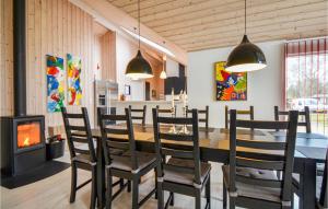 a dining room with a table and chairs and a fireplace at Four-Bedroom Holiday Home Glesborg With A Room Hot Tub 07 in Fjellerup