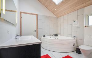 a bathroom with a tub and a toilet and a sink at Four-Bedroom Holiday Home Glesborg With A Room Hot Tub 07 in Fjellerup +22 photos