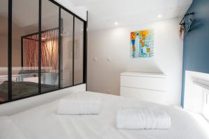 sypialnia z białym łóżkiem i dużym oknem w obiekcie LE CHANCEUX fabuleux duplex en design, pour loisir en couple ou congrès w Cannes