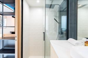 łazienka z przeszkloną kabiną prysznicową i umywalką w obiekcie LE CHANCEUX fabuleux duplex en design, pour loisir en couple ou congrès w Cannes