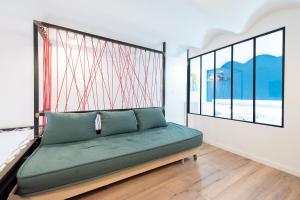zielone łóżko w pokoju z dużym oknem w obiekcie LE CHANCEUX fabuleux duplex en design, pour loisir en couple ou congrès w Cannes +8 zdjęć
