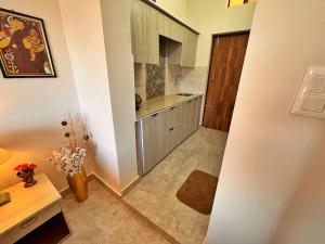 a small kitchen with white cabinets and a table at Vasantvasoj Homestay in Pauri