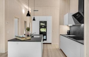 a kitchen with white cabinets and a black counter top at Cozy Home In Ebeltoft With Sauna in Ebeltoft