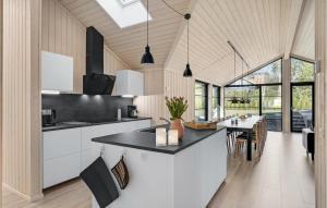 a kitchen with white cabinets and a black counter top at Cozy Home In Ebeltoft With Sauna in Ebeltoft