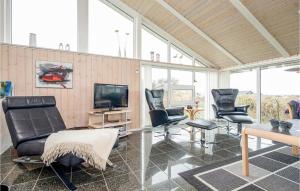 イェリングにあるFour-Bedroom Holiday Home In Hjorringのリビングルーム(黒い椅子、テレビ付)