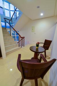 uma mesa e cadeiras num quarto com escadas em 海角203民宿 em Magong